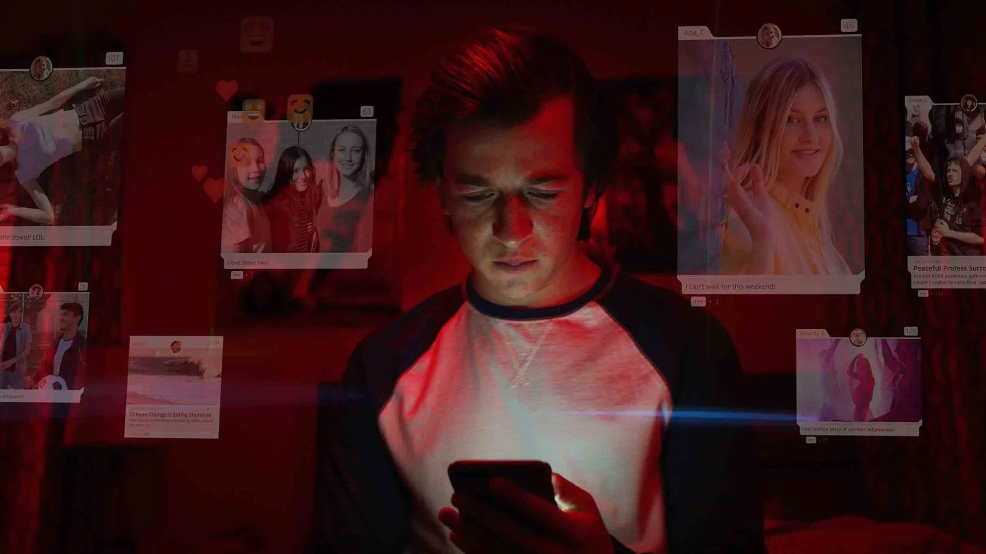 Screenshot aus dem Film: Das Dilemma mit den sozialen Medien. Junger Mann mit Handy in der Hand in einem dunklen Zimmer, Transparent eingeblendet Oberflächen von Social-Medie-PlattformenSOcial